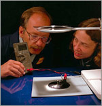 Photo of researchers testing the voltage output of their award-winning gallium indium phosphide/gallium arsenide tandem solar cell.