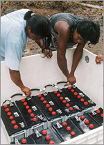 Photo of workers installing a PV/battery systems at Camp Leakey.