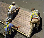 Photo of researchers installing PV shingles at the Outdoor Test Facility (OTF).