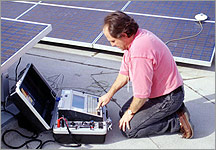 Photo of an NREL engineer measuring the current-voltage characteristics of a PV array.