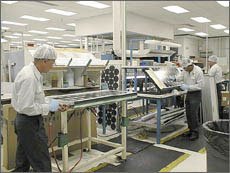 Photo of workers manufacturing pv panels.