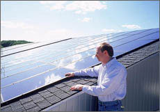 Photo of engineer examining a 17.2-kilowatt PV system on the roof of the Pennsylvania Department of Environmental Protection's Cambria Office Building.