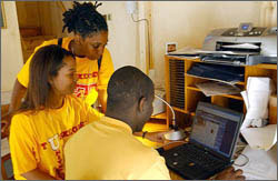 Photo of Tuskegee University Students working in a solar powered home office in their 2002 Solar Decathlon house.
