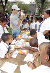 Photo of students receiving instruction about a variety of energy saving equipment at an outdoor workshop in the Solar Decathlon Village in Washington, D.C.