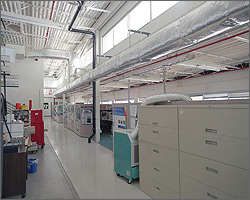 Photo of the inside of the NREL Thermal Test Facility with file cabinets and equipment lining the wall and light streaming in through rectangular windows.