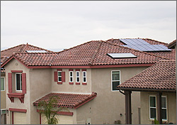 Photo of houses with solar water heating collectors on the roof.