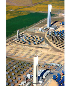 Photo of two lit towers surrounded by much smaller blue flat plates that are mounted on the ground.