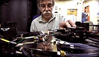 A man loads photovoltaic cells into measurement equipment in a laboratory.
