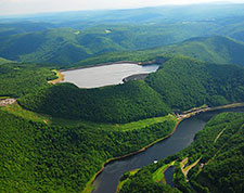 Photo of Bear Swamp Hydroelectric Power Station, with a reservoir located in the heart of a wooded, hilly area.