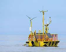 The OceanSentinel MHK testing unit in deployment, showing a floating station located in the middle of the ocean.