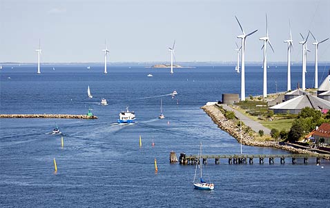 Photo of an offshore wind farm with several turbines spread out across the coast and offshore.