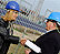 Photo of a man and a woman shaking hands in front of a photovoltaic (PV) array.