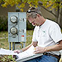 Photo of a weatherization worker reviewing notes conducted during an energy audit on a clipboard.