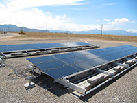 Photo of blue-gray solar panels on the ground.